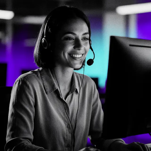 Agente de servicio al cliente con audífonos frente a un monitor