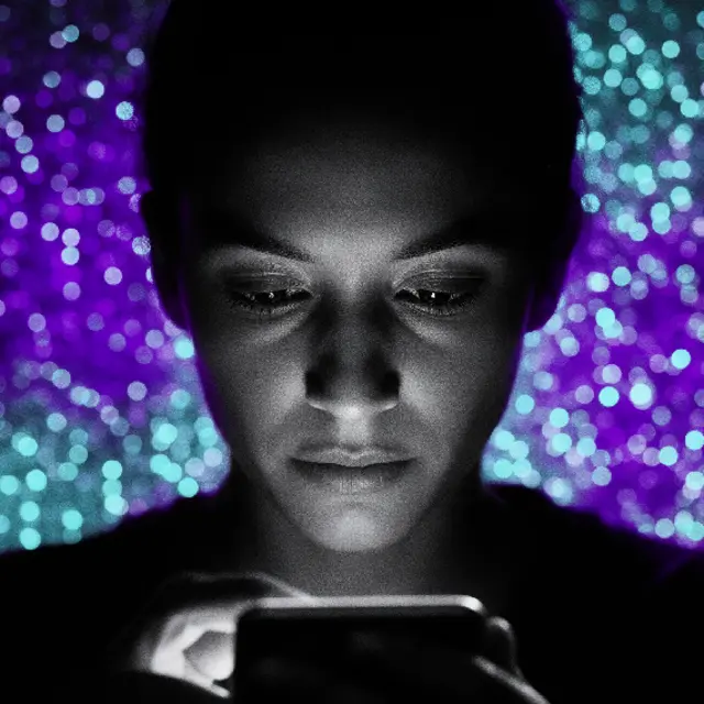 Rostro iluminado por la pantalla de un celular